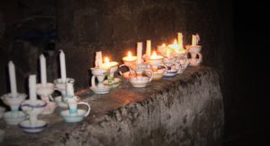 Candlelight from candles in holders in dark cave