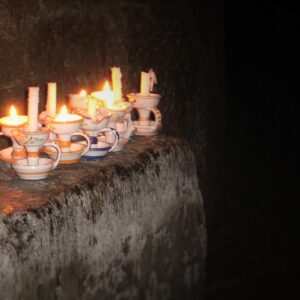 Candlelight from candles in holders in dark cave
